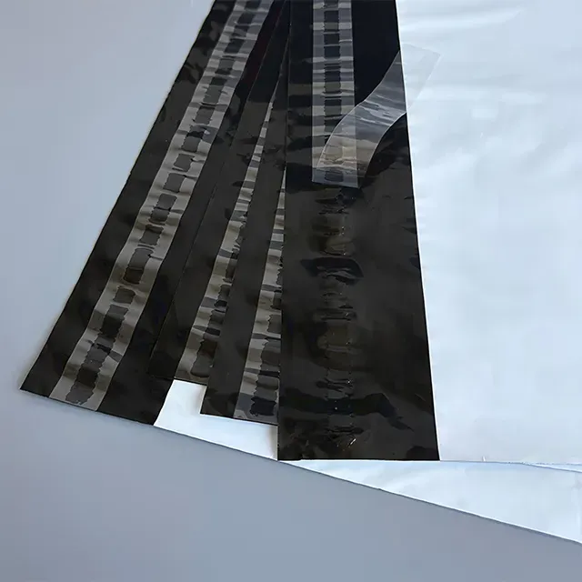 white mailing bag White polyethylene mailer bags with self-sealing adhesive strips stacked on a grey background, showing durable tear-resistant shipping packaging for e-commerce deliveries.